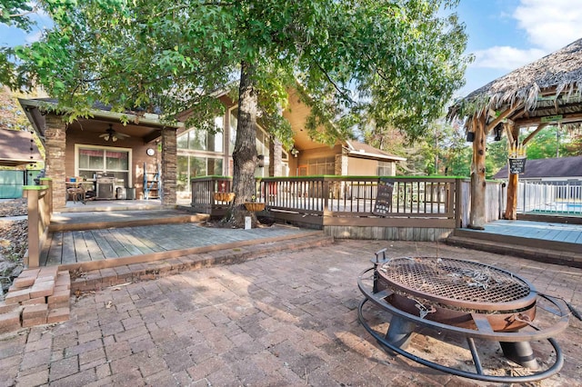 view of patio featuring a fire pit, ceiling fan, and a deck