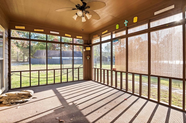 unfurnished sunroom featuring ceiling fan and wood ceiling