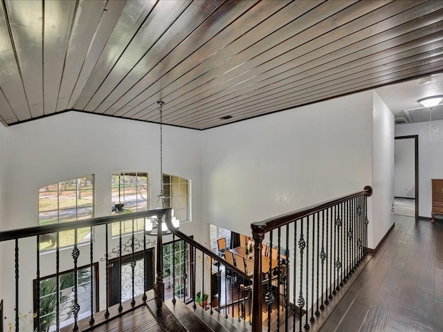 hall with wood ceiling, attic access, vaulted ceiling, an upstairs landing, and wood-type flooring