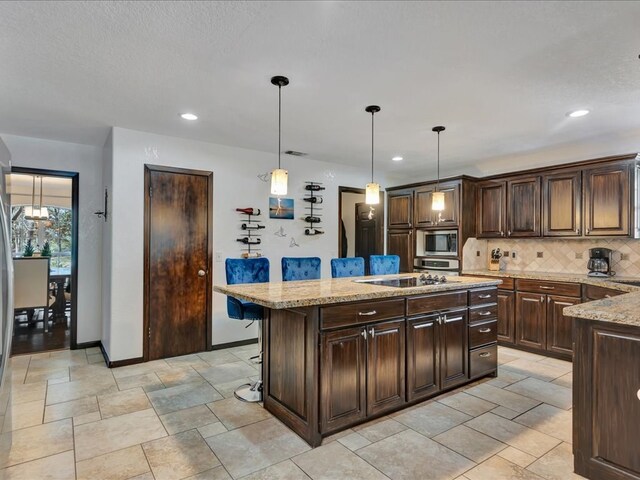 kitchen featuring appliances with stainless steel finishes, a kitchen island, and pendant lighting