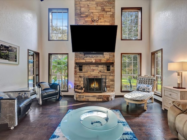 living room featuring a fireplace, dark wood-type flooring, and a high ceiling