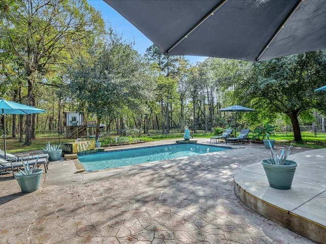 pool with a patio and fence