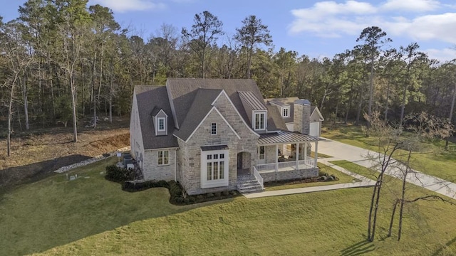 view of front of house with stone siding, a porch, and a front lawn