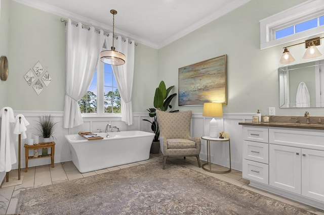 bathroom with vanity, a freestanding bath, wainscoting, and crown molding