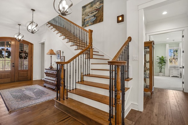 foyer entrance with arched walkways, plenty of natural light, ornamental molding, and hardwood / wood-style flooring