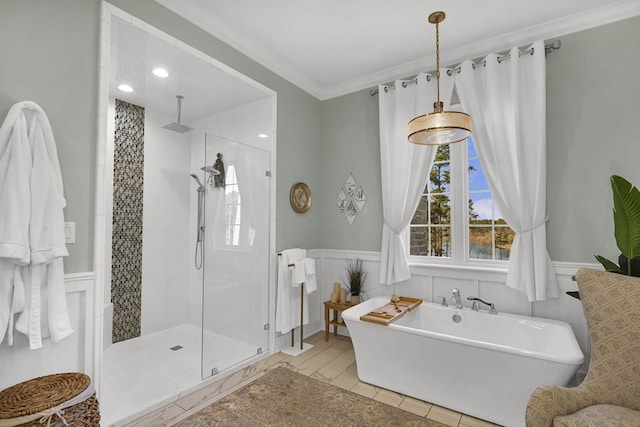 full bathroom featuring a wainscoted wall, a freestanding bath, ornamental molding, a shower stall, and tile patterned floors