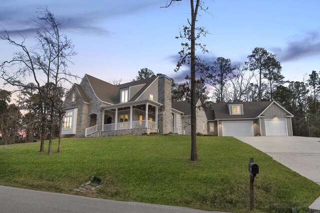 view of front of property with stone siding, concrete driveway, and a front lawn