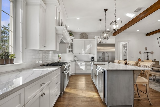 kitchen featuring visible vents, high quality appliances, a kitchen bar, beam ceiling, and decorative backsplash