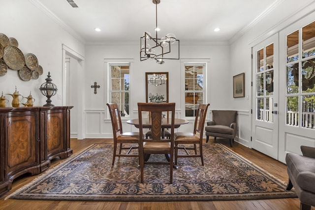 dining space with dark wood-style floors, plenty of natural light, and ornamental molding