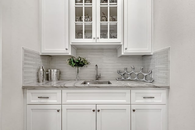 bar featuring tasteful backsplash and a sink