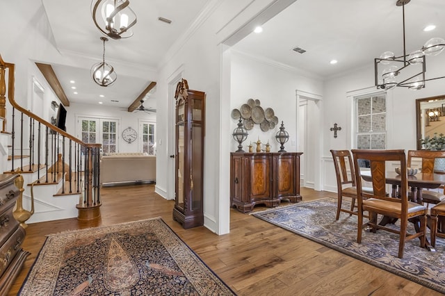 entryway with visible vents, wood finished floors, recessed lighting, stairway, and crown molding