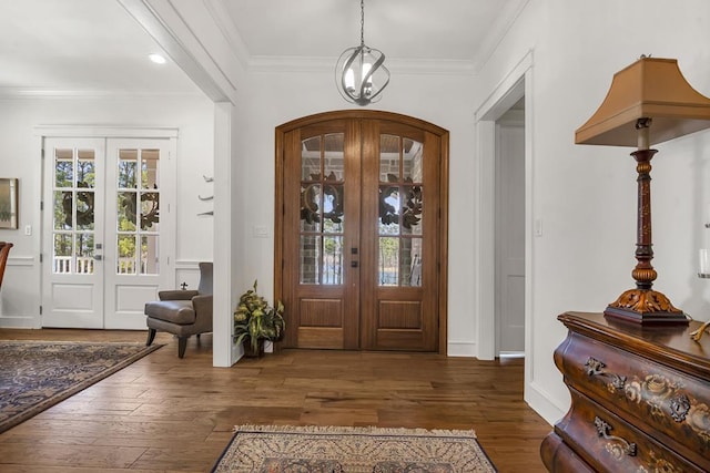 foyer entrance with french doors, crown molding, and wood finished floors