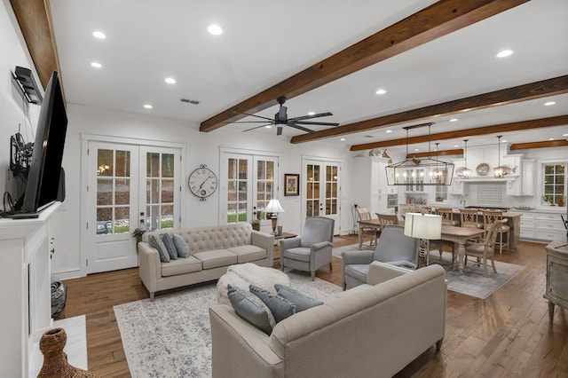 living room with visible vents, a healthy amount of sunlight, beamed ceiling, french doors, and hardwood / wood-style flooring