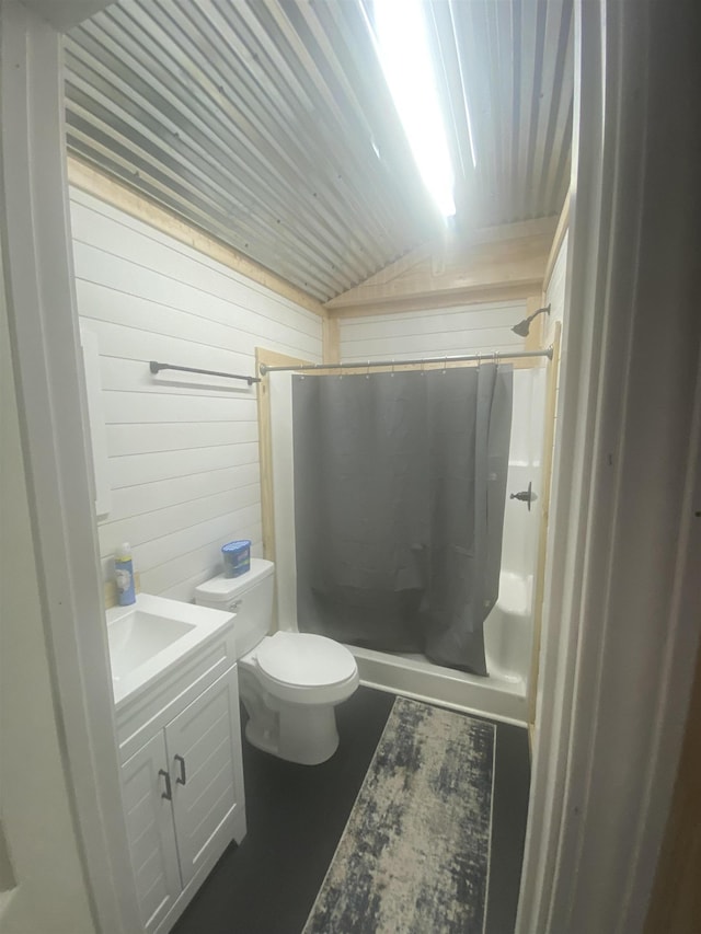 bathroom with a shower with shower curtain, vanity, wood walls, and toilet