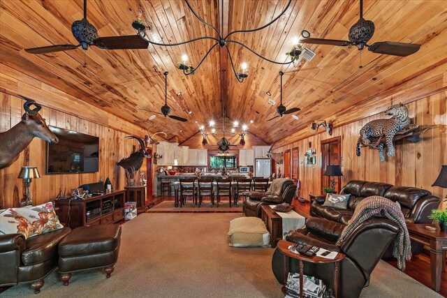 living room featuring ceiling fan, wood walls, and wooden ceiling