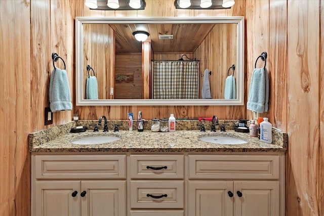 334 Pineknot Ln, Milam, TX 75959 - full bathroom featuring double vanity, wood walls, and a sink