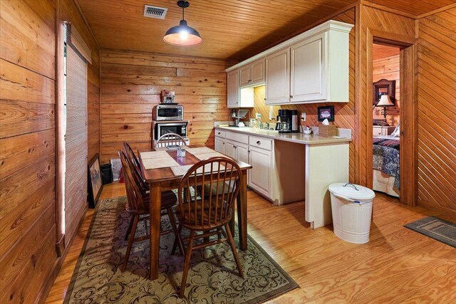 living room featuring ceiling fan, wooden ceiling, wood-type flooring, and wooden walls