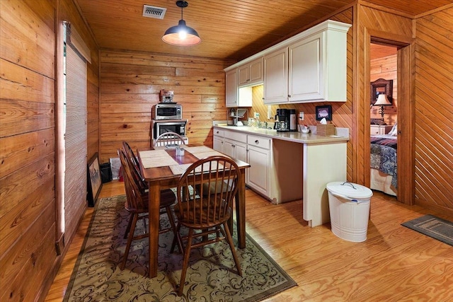 334 Pineknot Ln, Milam, TX 75959 - kitchen with visible vents, light wood-style flooring, wooden walls, light countertops, and wood ceiling