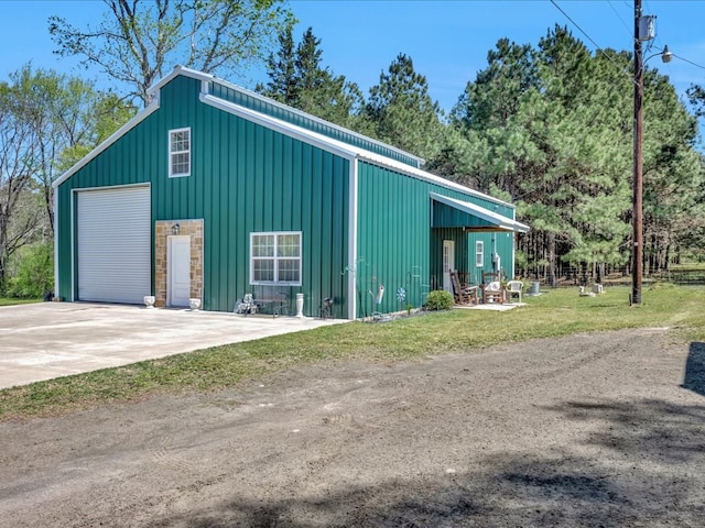view of pole building featuring driveway and fence