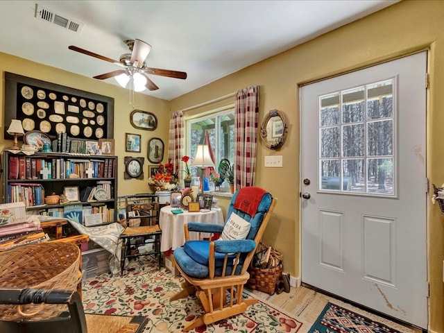 sitting room featuring visible vents, a ceiling fan, and wood finished floors