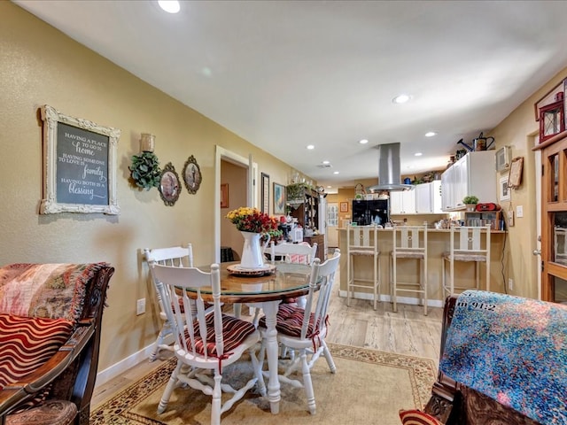 dining room featuring light wood-style flooring, baseboards, and recessed lighting