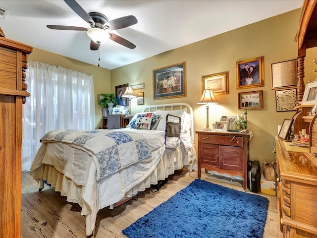 bedroom with visible vents, a ceiling fan, and wood finished floors