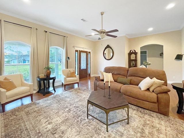 living room featuring crown molding, wood-type flooring, and ceiling fan