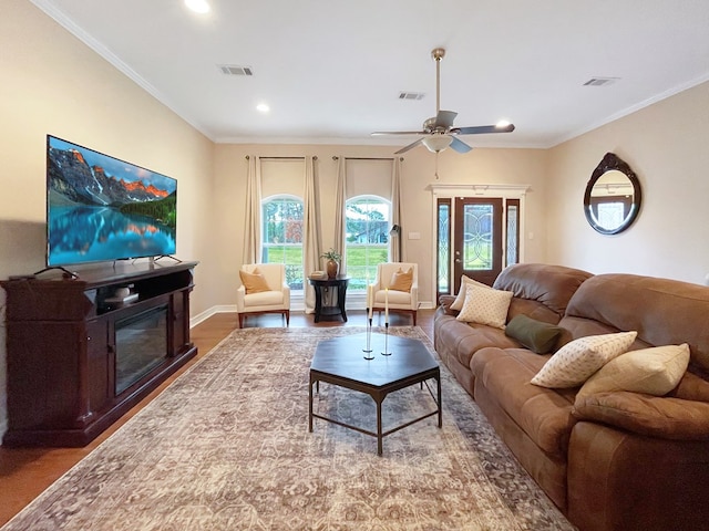 living room with crown molding, ceiling fan, and wood-type flooring