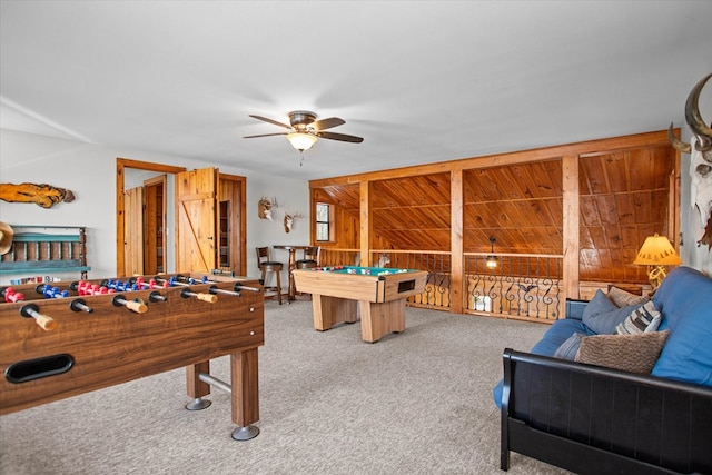 recreation room featuring wood walls, carpet flooring, a ceiling fan, and billiards