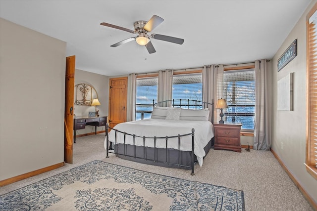 bedroom with carpet flooring, baseboards, and multiple windows