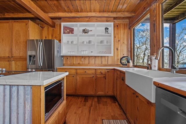kitchen with plenty of natural light, a sink, light countertops, light wood-style floors, and stainless steel appliances