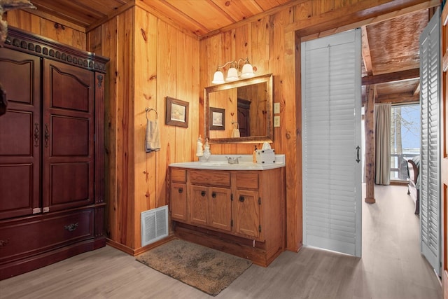 bathroom with wood walls, visible vents, wood ceiling, and wood finished floors