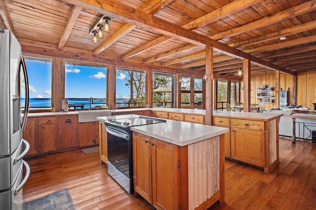 kitchen with wooden ceiling, a center island, beamed ceiling, stainless steel appliances, and a sink