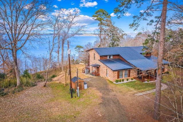 view of front of home with metal roof, a standing seam roof, and a front lawn