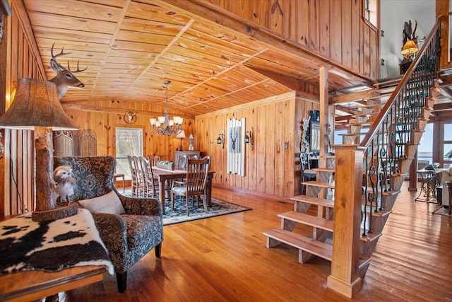 living area featuring wooden ceiling, wooden walls, and stairs