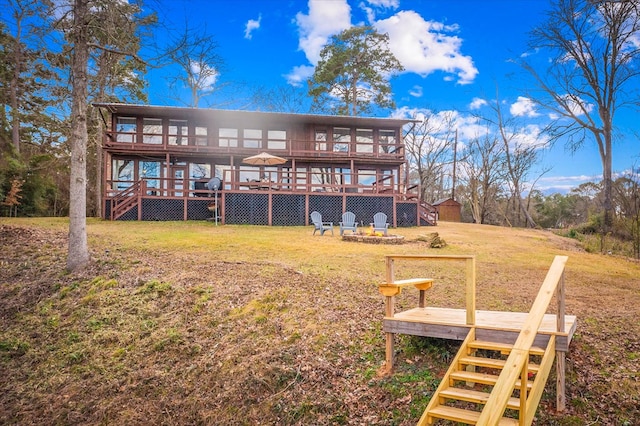 back of property with a yard, a deck, and stairs