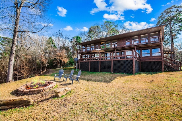 back of house with an outdoor fire pit, a lawn, a wooden deck, and stairway