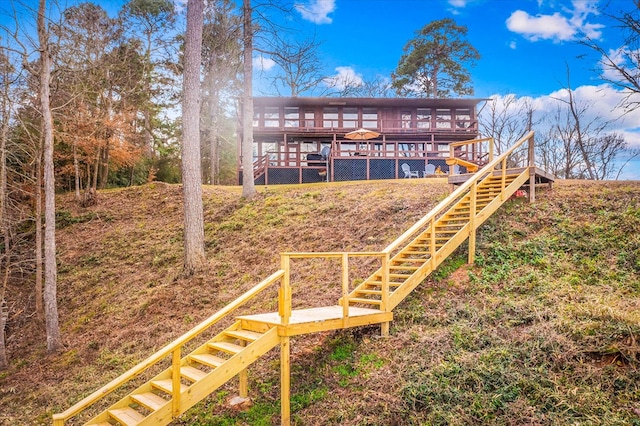 back of property featuring stairway and a deck