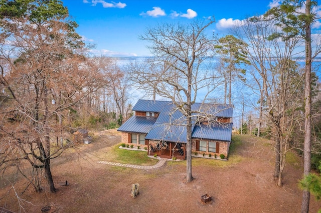 view of front of home with brick siding and metal roof
