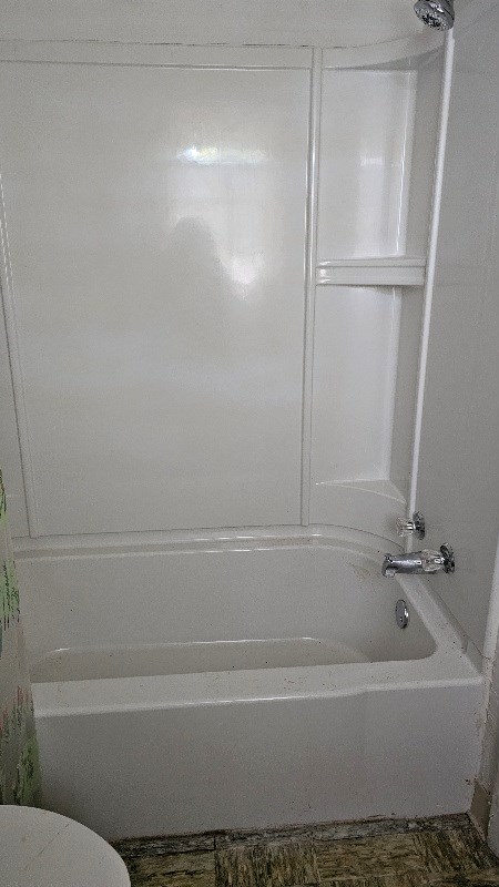 bathroom featuring shower / tub combination and toilet