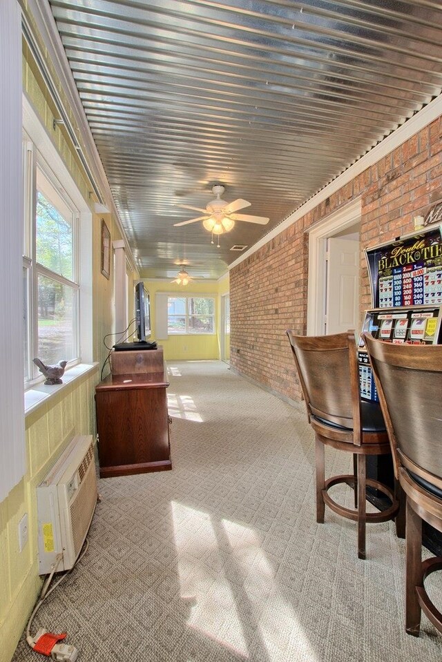 sunroom / solarium with ceiling fan and a wall mounted AC