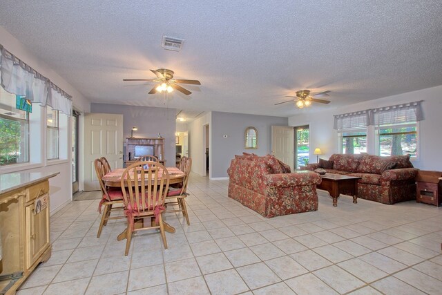 tiled dining space featuring ceiling fan and a textured ceiling