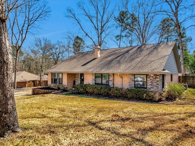 view of front of property featuring brick siding, a chimney, a shingled roof, fence, and a front lawn