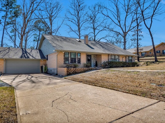 view of front facade with a garage, concrete driveway, a chimney, roof with shingles, and brick siding