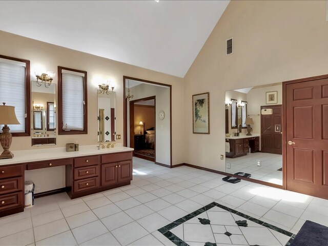 bathroom with tile patterned flooring, vanity, and high vaulted ceiling