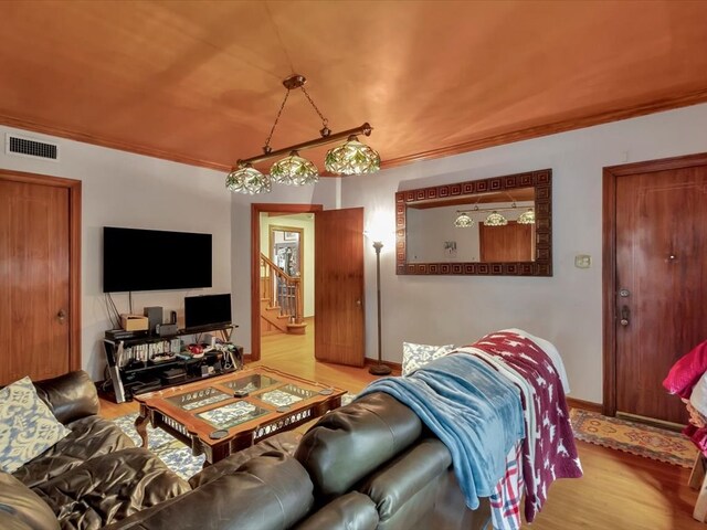 living room with crown molding and light wood-type flooring