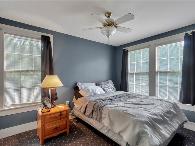 bedroom featuring carpet flooring, ceiling fan, and multiple windows