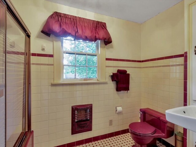 bathroom with tile patterned floors, tile walls, and toilet