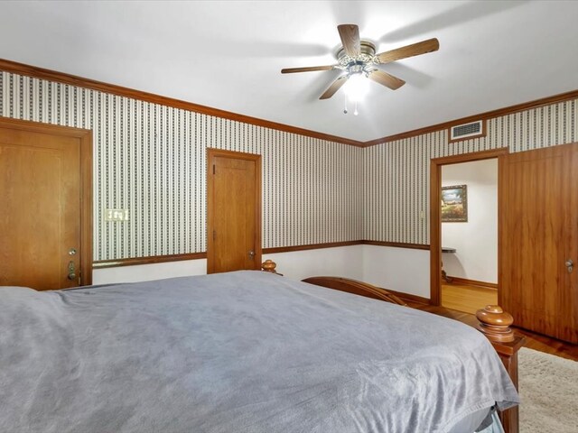 unfurnished bedroom with hardwood / wood-style flooring, ceiling fan, and crown molding