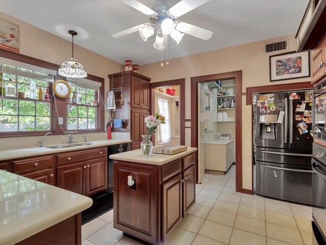 kitchen with pendant lighting, a center island, sink, stainless steel refrigerator with ice dispenser, and light tile patterned floors